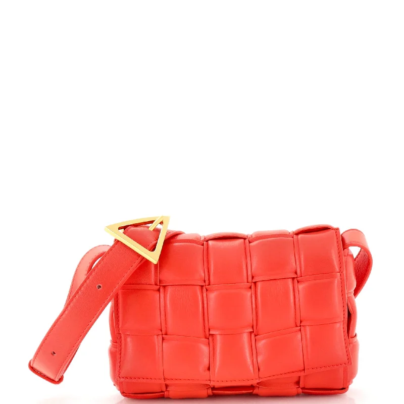 Vibrant orange crossbody bags popping against muted outfits -Cassette Crossbody Bag Padded Maxi Intrecciato Leather Small